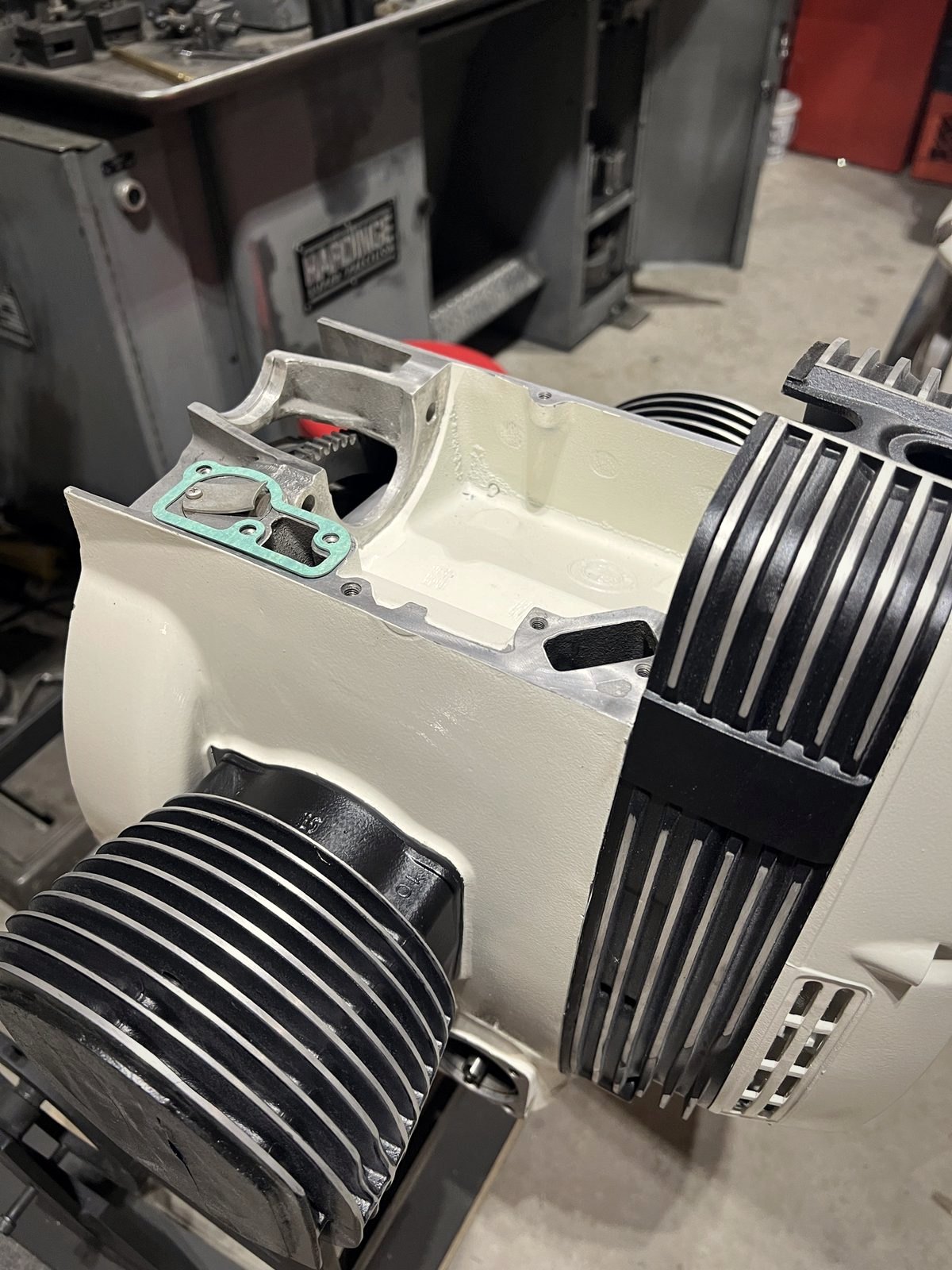 A bare BMW airhead crankcase mounted on a black steel engine stand in a workshop
