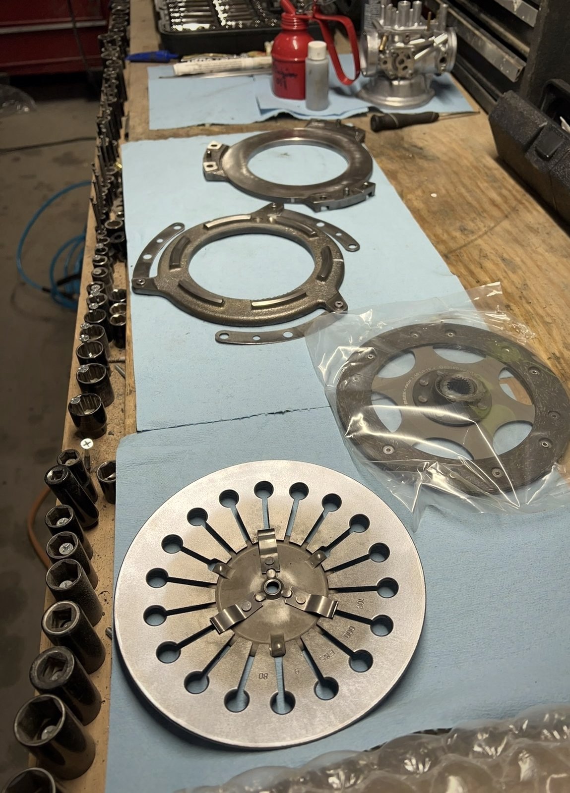 Clutch pressure plate, diaphragm spring and a new friction disc laid out on blue towels
