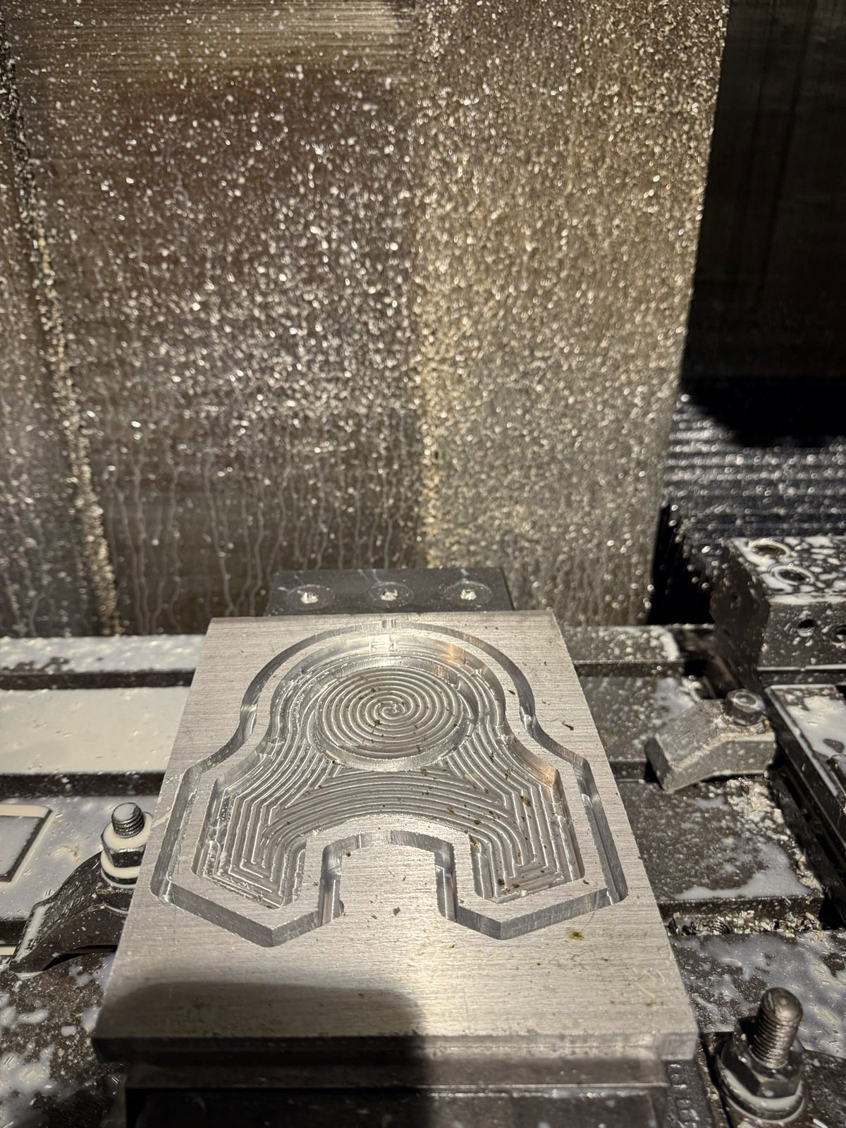 An aluminium casting being machined, swarf on the mill table