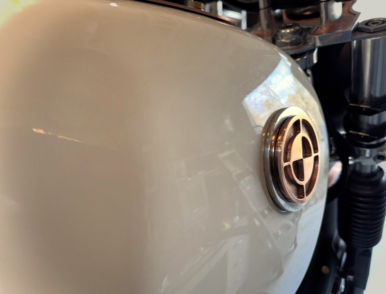 The BMW roundel on a black tank, in shadow