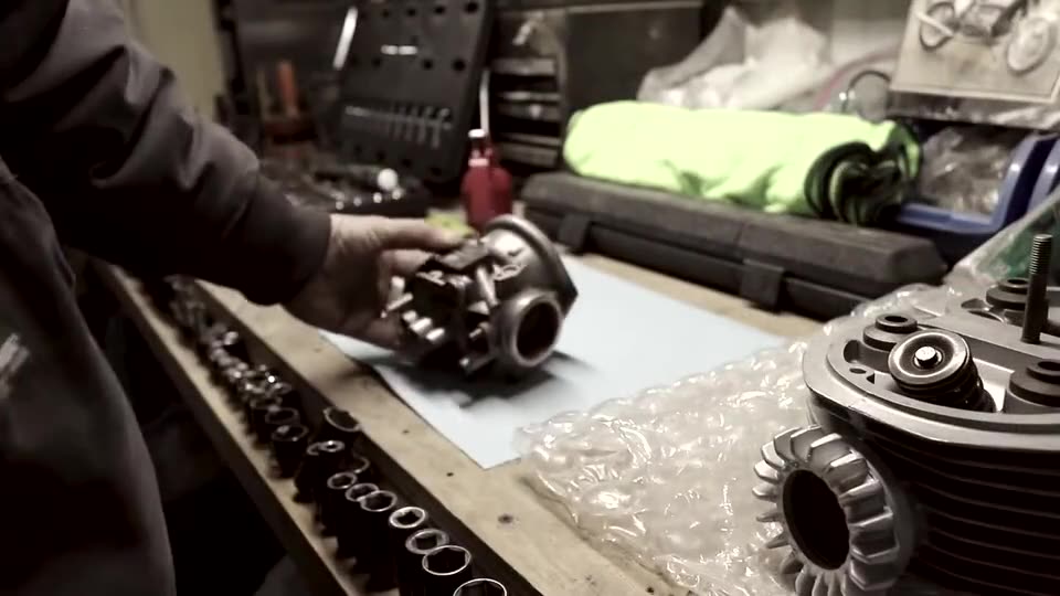 An oil pump cover and O-ring on a workbench beside a red oil can